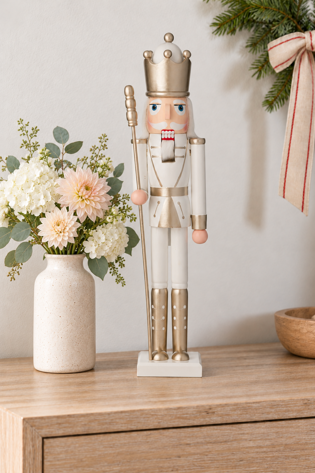 White and champagne-gold60cm crowned nutcracker beside summer hydrangeas and dahlias on a lightly whitewashed timber console; Coast to Coast XM0132