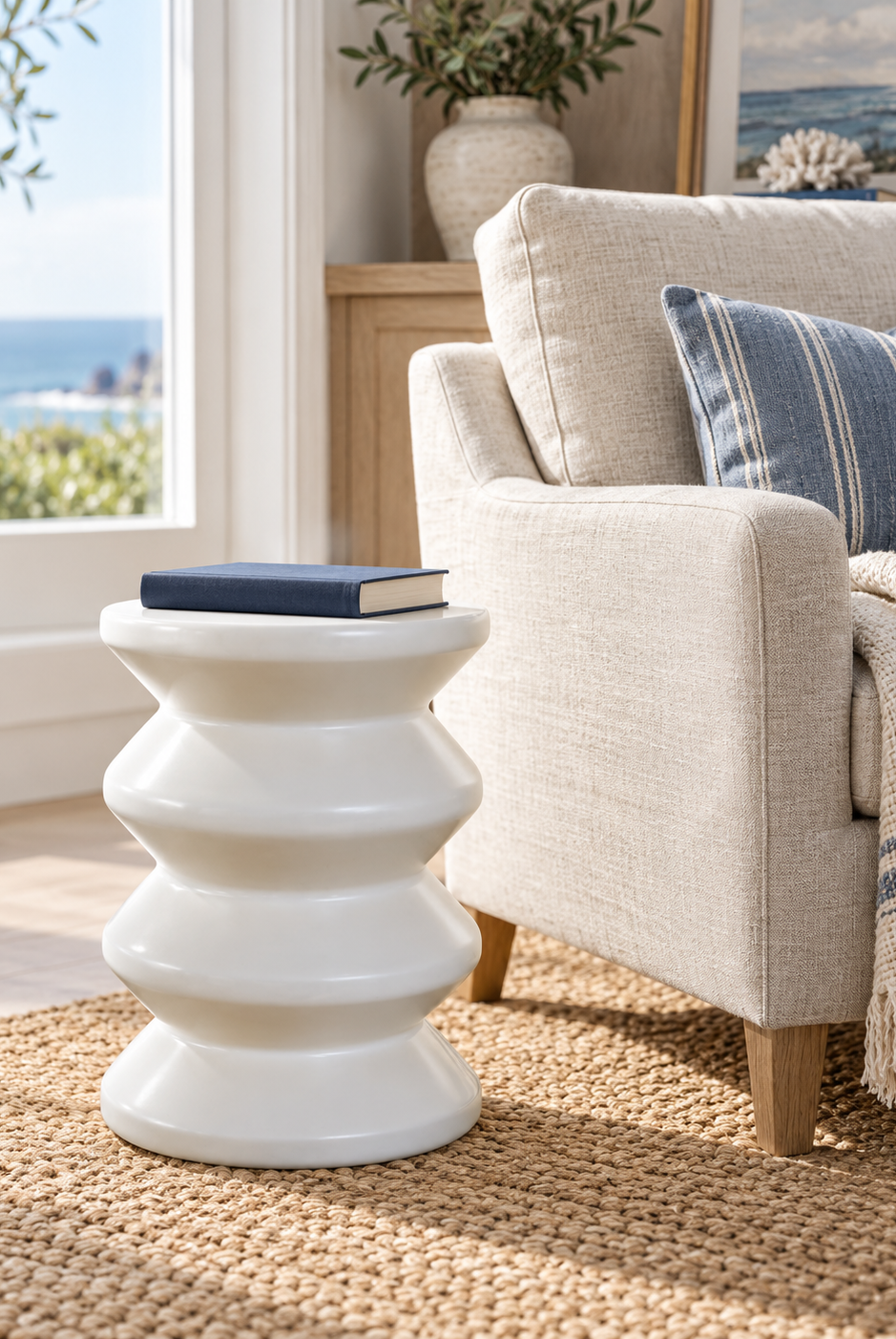 Torano glazed white stool styled in a coastal reading corner