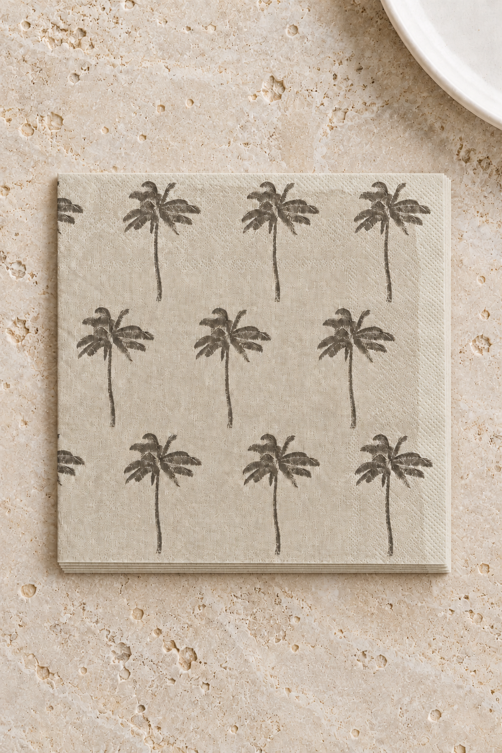 Siesta Paper Napkins - Natural and Grey in a precisely aligned thin paper stack, viewed overhead on a pale stone bench; Coast to Coast KW5452