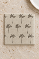 Siesta Paper Napkins - Natural and Grey in a precisely aligned thin paper stack, viewed overhead on a pale stone bench; Coast to Coast KW5452