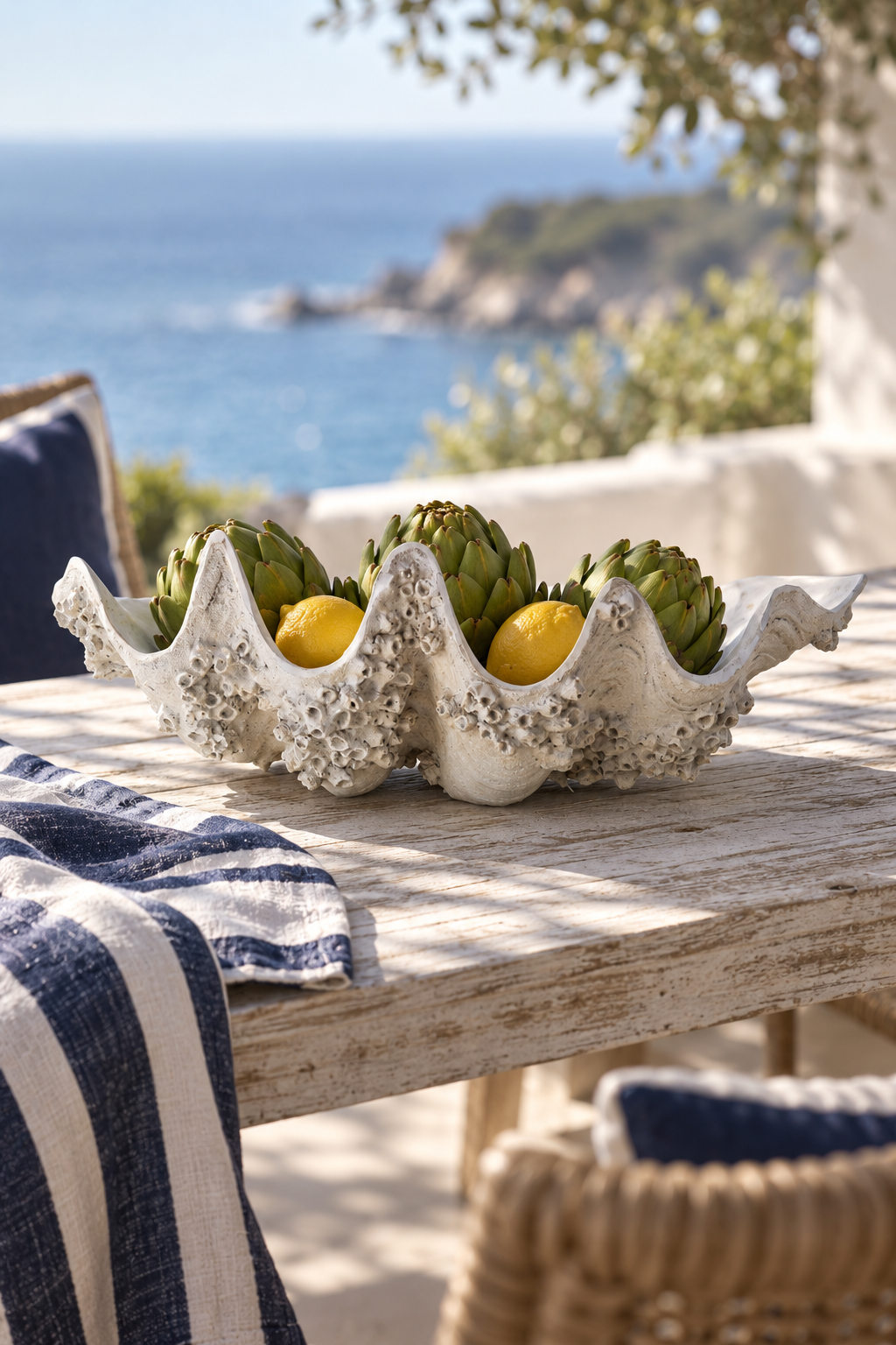 Trida clam vessel styled with artichokes and lemons beside the sea
