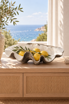 Extra large natural resin clam shell styled with lemons in a coastal home