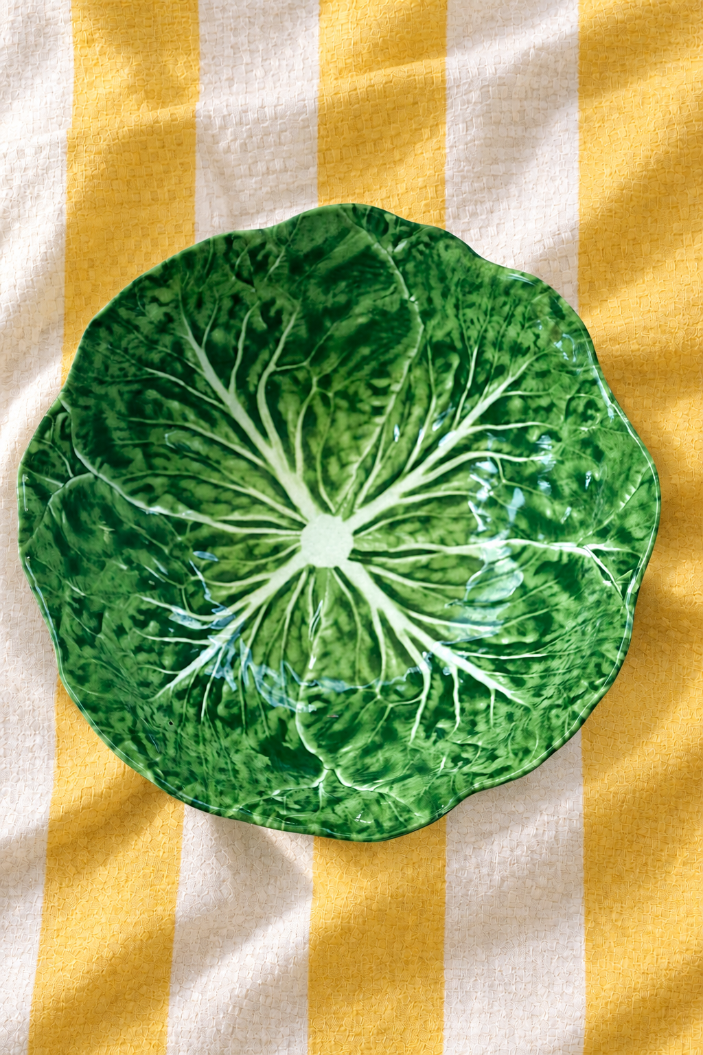 Green Medium Bowl – Cabbage Melamine on yellow and white striped tablecloth