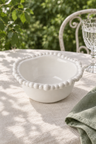 White Pearl Melamine small snack bowl styled outdoors with green linen